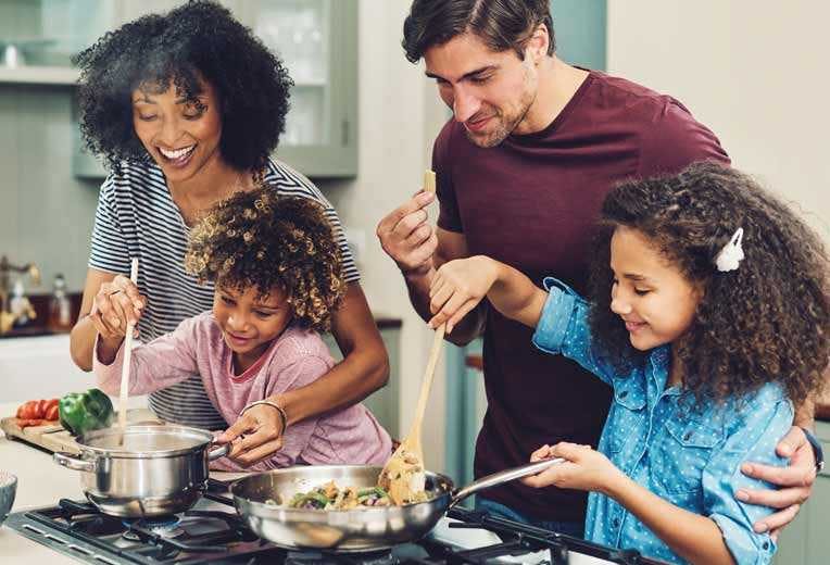 A family in their kitchen cooking dinner together.