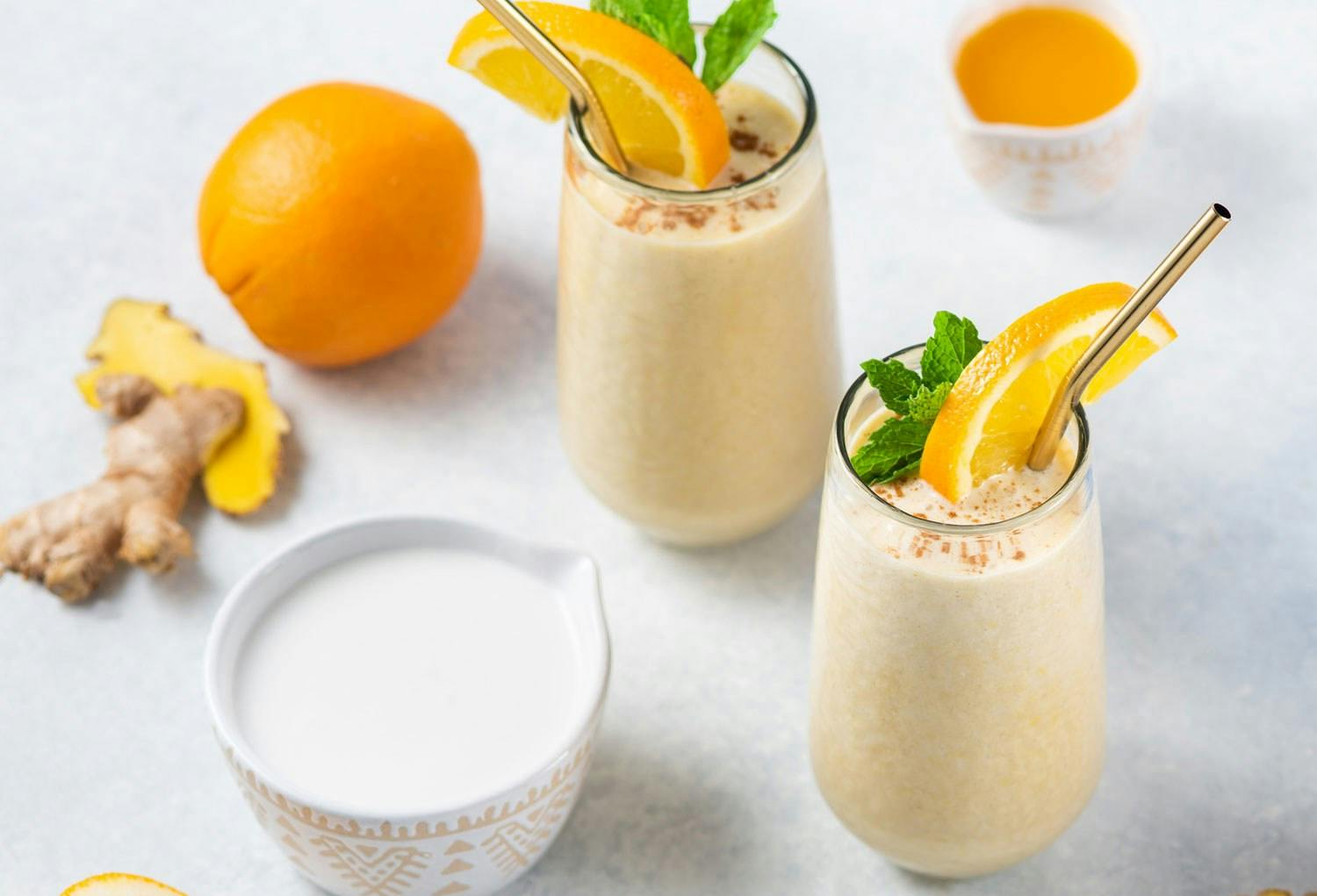 Two Premier Protein shakes in cups made with Premier Protein Vanilla Shake Powder.