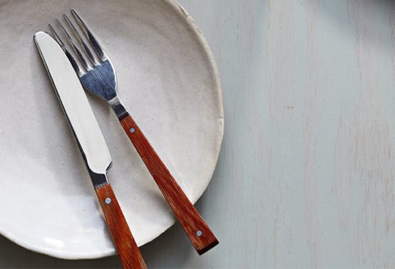 An empty plate with a fork and knife.