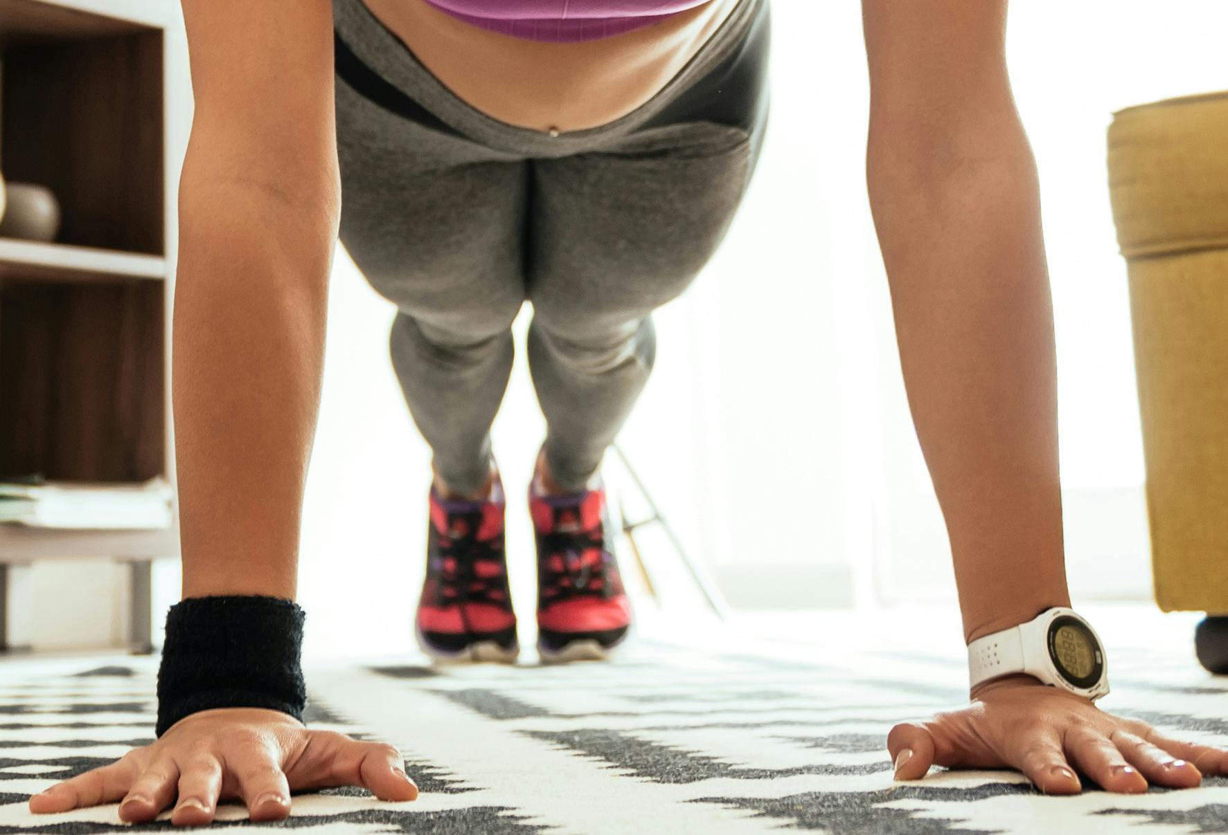 A person doing a pushup in their living room.