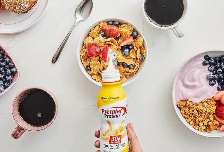 Cereal with Premier Protein on a table along with other breakfast items..