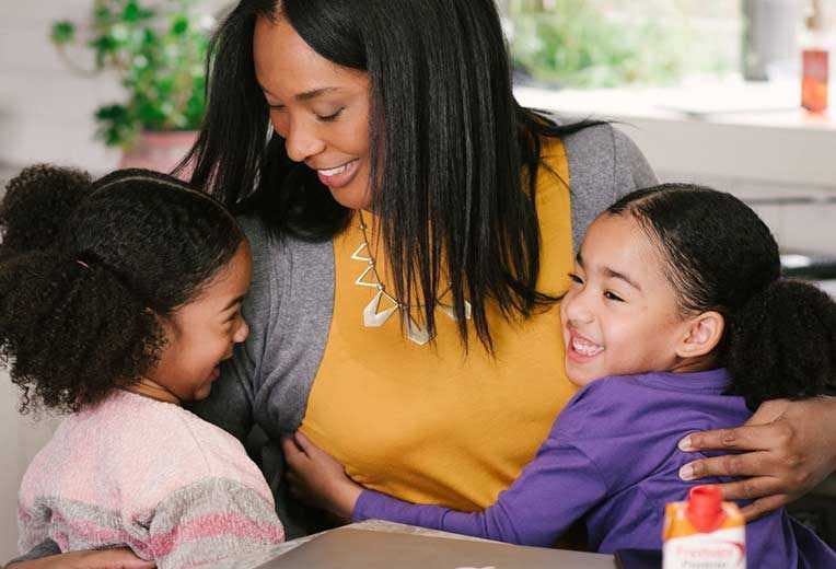 A mom drinking Premier Protein while enjoying quality time with her children.