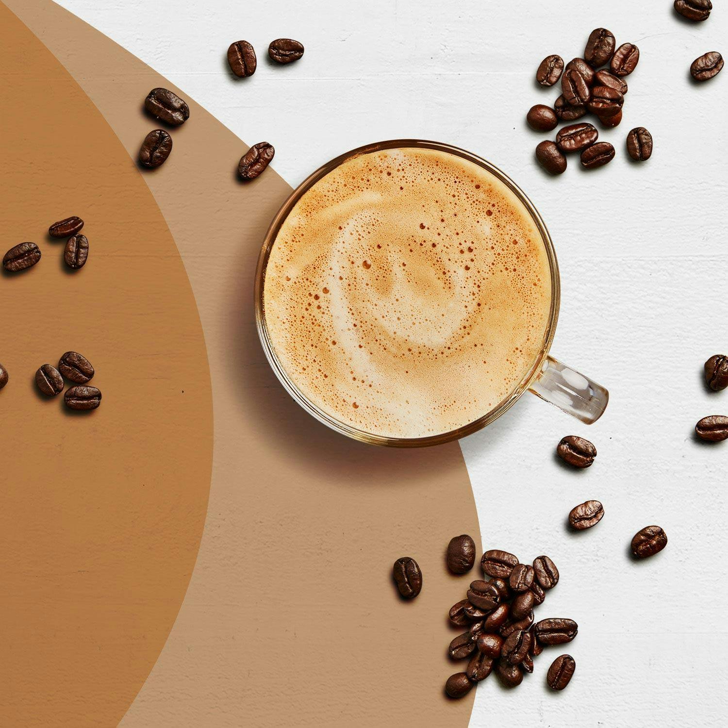 A Cafe Latte Premier Protein shake surrounded by coffee beans..