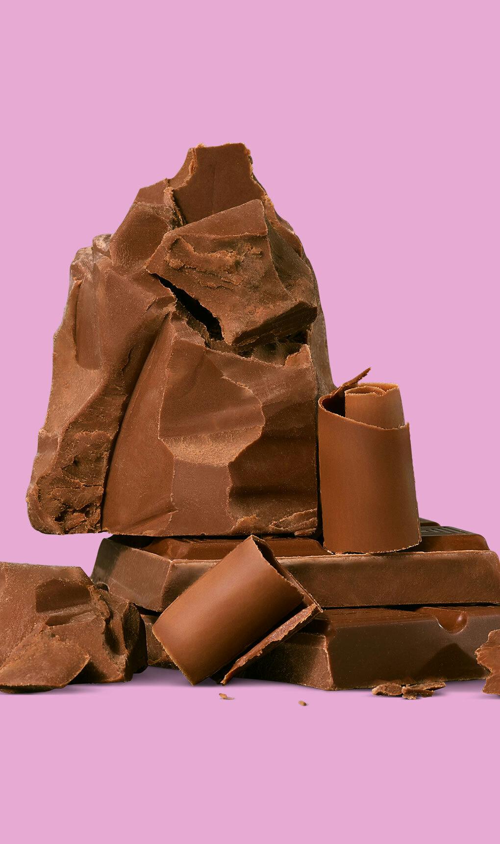 Chocolate chunks and swirls against a pink background.