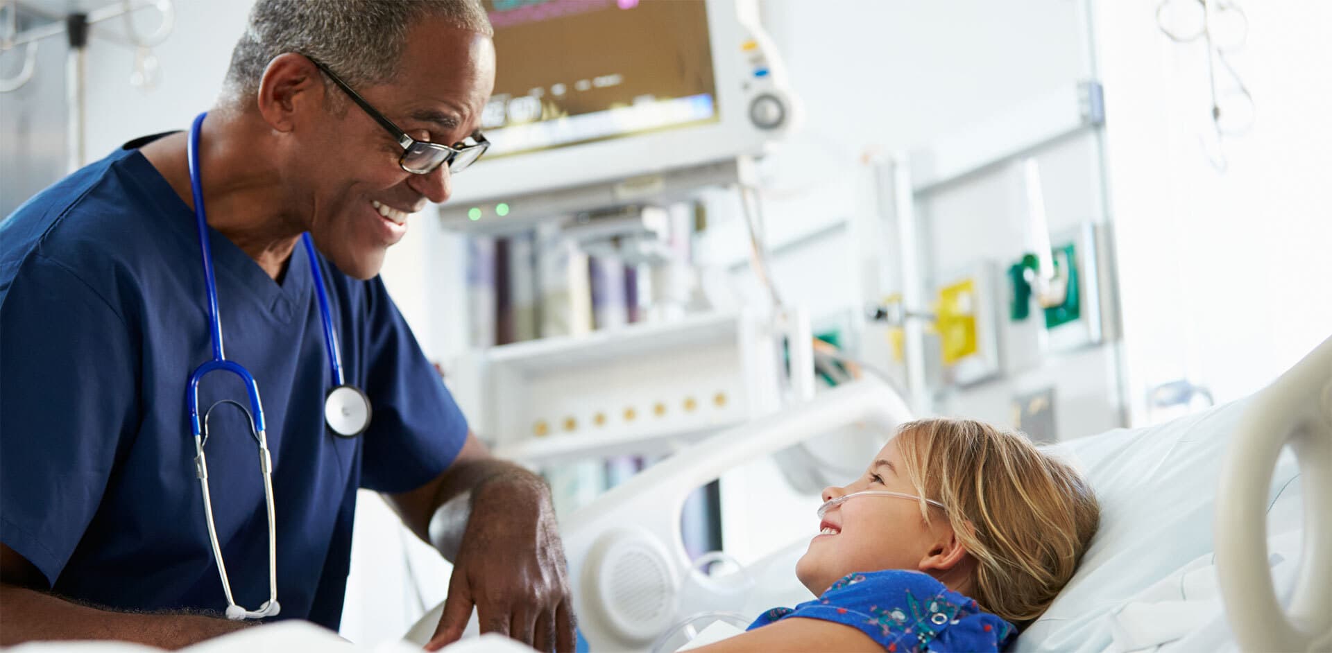 a male nurse cares for an injured child in a hospital room